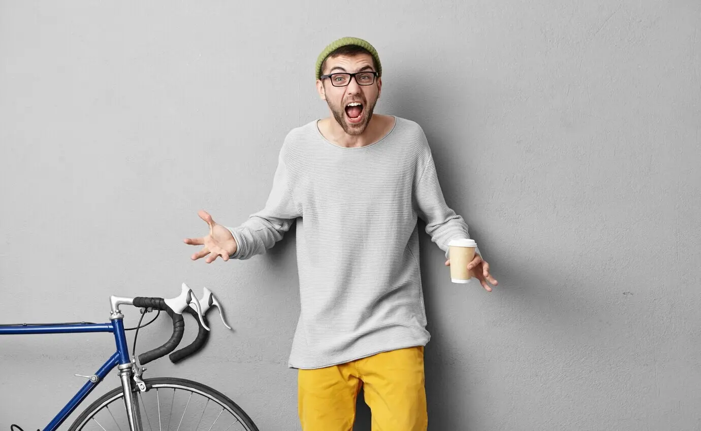 Stilvoller, attraktiver Mann, der sich mit seiner Frau streitet, seine Wochenenden nicht mit ihr, sondern mit seinen besten Freunden verbringen will, für sie das Fahrzeug nicht reparieren möchte und Kaffee zum Mitnehmen trinkt.